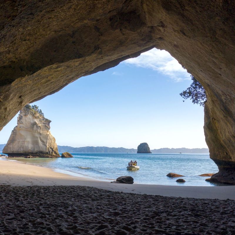 a group of people on a rock next to a body of water