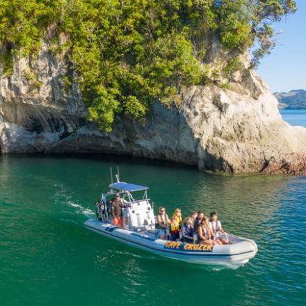 a group of people riding on the back of a boat in the water